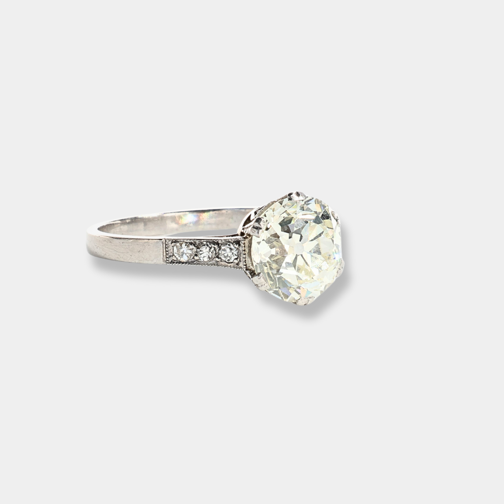 Anello in oro bianco con diamante centrale importante e diamanti sul gambo