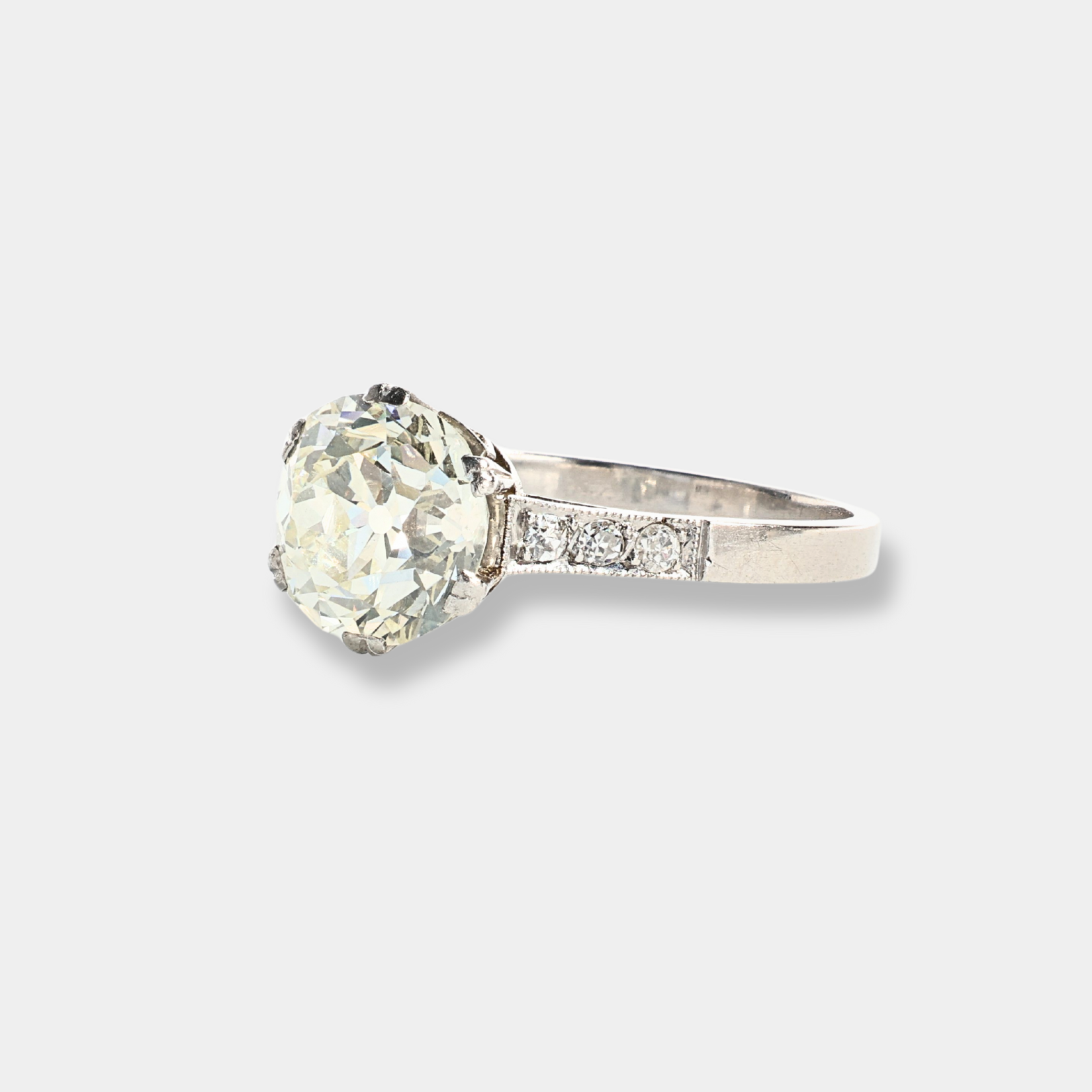 Anello in oro bianco con diamante centrale importante e diamanti sul gambo